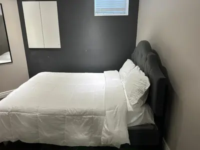 a bedroom with a bed with a white comforter at Cozy and comfy 2 Bed rooms in Mississauga