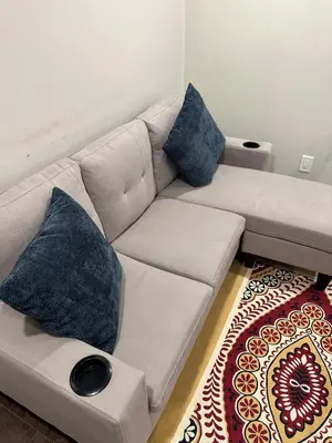 a white couch with blue pillows in a living room at Cozy and comfy 2 Bed rooms in Mississauga
