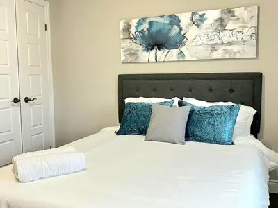 a bedroom with a white bed with blue pillows at Fieldstone Estate in Tillsonburg