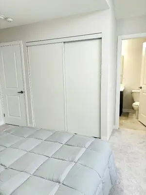 a white bedroom with a large bed and a bathroom at Cozy Private Room with ensuite in Shared Home in Ayr in Paris