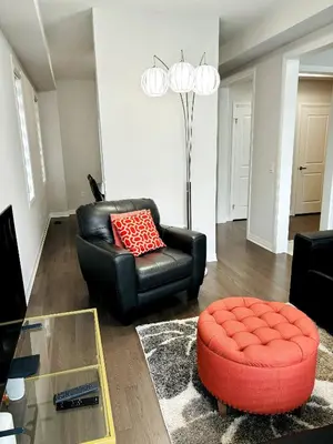 a living room with a black leather chair and a red stool at Cozy Private Room with ensuite in Shared Home in Ayr in Paris
