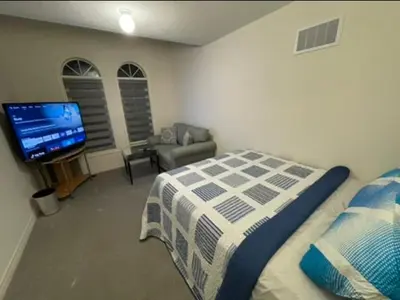 a bedroom with a bed and a flat screen tv at Budget Friendly Home in Oshawa