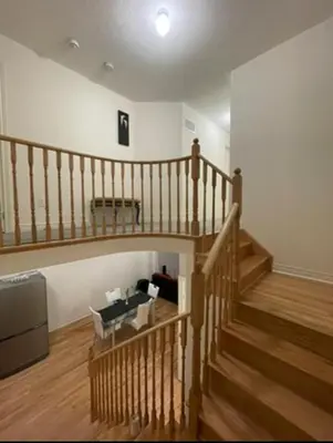 a living room with a staircase with a couch and a stair case at Budget Friendly Home in Oshawa