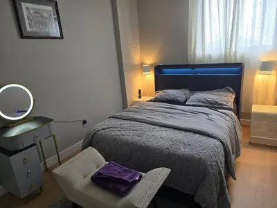 a bedroom with a bed and a chair and a mirror at Simple entire apartment 2 bedroom night rest in Kitchener