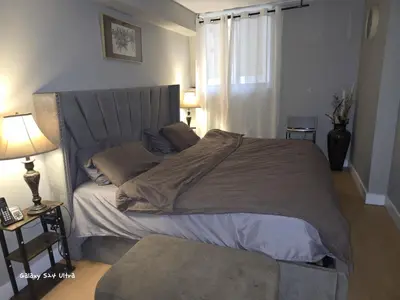 a large bed in a bedroom with a lamp at Simple entire apartment 2 bedroom night rest in Kitchener