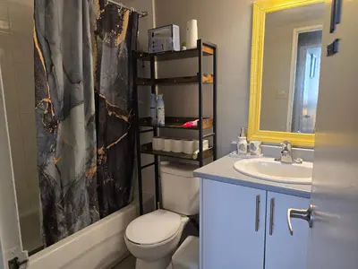 a bathroom with a toilet and a sink and a mirror at Simple entire apartment 2 bedroom night rest in Kitchener