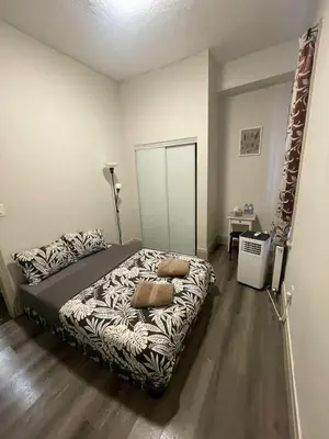 a bedroom with a bed with two pillows on it at Homestay At Queen St-Downtown Toronto-Free Wifi N in Toronto