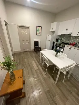 a kitchen with a white table and chairs in a room at Homestay At Queen St-Downtown Toronto-Free Wifi N in Toronto