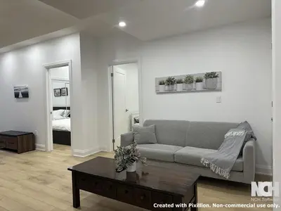 a living room with a couch and a coffee table at Modern 2-Bedroom Apartment in Luxury Home with Gym in Richmond Hill