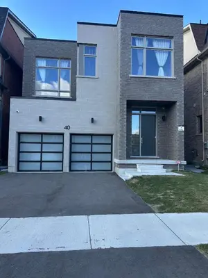 a house with two garage doors and a driveway at Modern 2-Bedroom Apartment in Luxury Home with Gym in Richmond Hill
