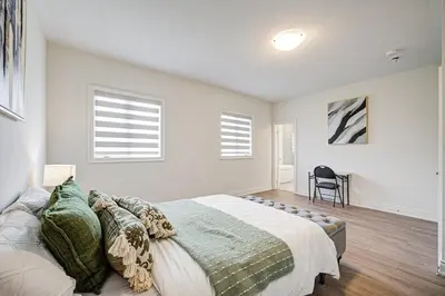 a bedroom with a large bed and two windows at Modern Spacious Luxury detached-House new in RH in Richmond Hill