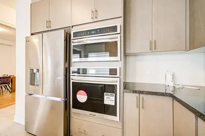 a kitchen with a stainless steel refrigerator and cabinets at Very Modern New Luxury House in RichmondHill in Richmond Hill