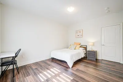 a white bedroom with a bed and a desk at Very Modern New Luxury House in RichmondHill in Richmond Hill