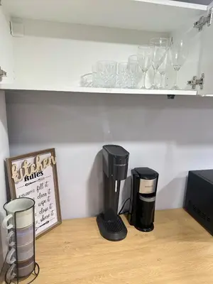 a counter with a coffee maker and glasses on a shelf at Soft Landing Spot Basement Hideout 2 bedroom apartment in Ajax