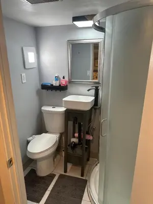 a bathroom with a toilet and a sink and a shower at Soft Landing Spot Basement Hideout 2 bedroom apartment in Ajax