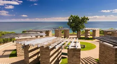 a row of benches with the ocean in the background at Soft Landing Spot Basement Hideout 2 bedroom apartment in Ajax
