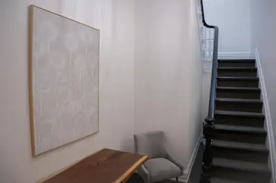 a stairway with a table and a chair and a picture at Downtown Stratford - The Blowes Inn in Stratford