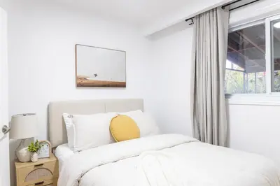 a white bedroom with a bed and a window at Private 2-BR Suite w Patio in Mississauga