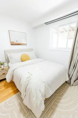a white bedroom with a bed and a window at Private 2-BR Suite w Patio in Mississauga