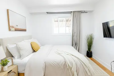 a white bedroom with a bed and a window at Private 2-BR Suite w Patio in Mississauga