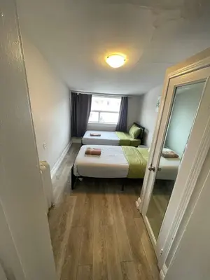 a small room with two beds and a mirror at Affordable Toronto Downtown Bloor Stay in Toronto