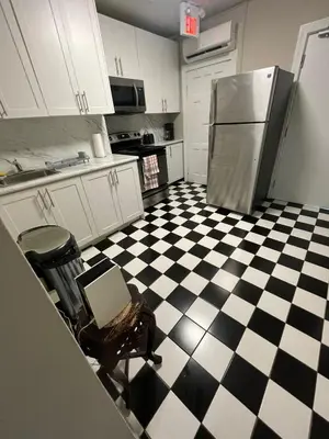 a kitchen with a black and white checkered floor at Affordable Toronto Downtown Bloor Stay in Toronto