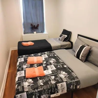 a bedroom with two beds and a window at Sweet Home in Bloor Downtown-CENTRAL STAY in Toronto