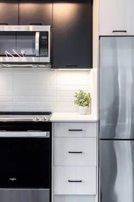 a kitchen with a stainless steel refrigerator and a microwave at Chic 2-Bedroom Apartment with Parking in Toronto