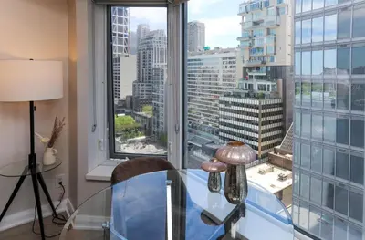 a glass table in a room with a large window at Cozy Studio in the heart of Yorkville in Toronto