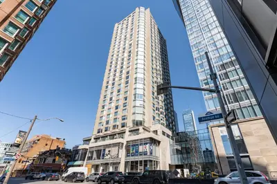 a tall building with cars parked in front of it at Cozy Studio in the heart of Yorkville in Toronto