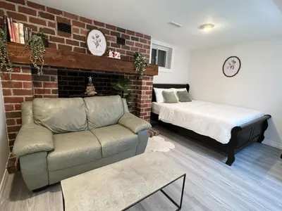 a bedroom with a couch and a bed and a brick wall at Modern Newly-Renovated Suite Free Parking in Toronto
