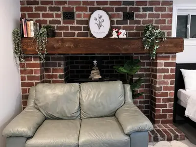 a leather couch in front of a brick fireplace at Modern Newly-Renovated Suite Free Parking in Toronto