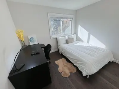 a bedroom with a bed and a desk with a teddy bear on the floor at Modern Newly-Renovated Suite Free Parking in Toronto