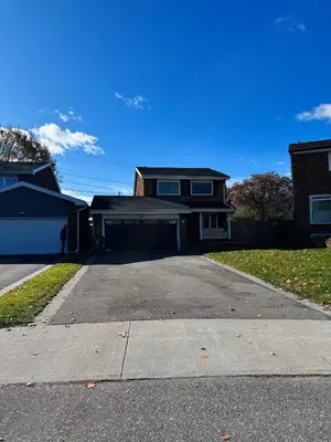 a house with a driveway in front of a house at Modern Newly-Renovated Suite Free Parking in Toronto