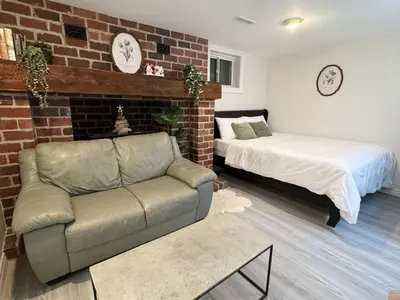 a bedroom with a couch and a bed and a brick wall at Modern Newly-Renovated Suite Free Parking in Toronto