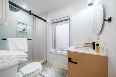 a bathroom with a toilet and a sink and a window at Luxury Group Stay in King West in Toronto