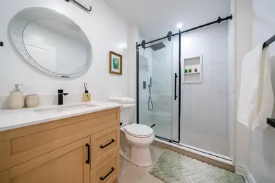 a bathroom with a toilet and a shower with a mirror at Luxury Group Stay in King West in Toronto