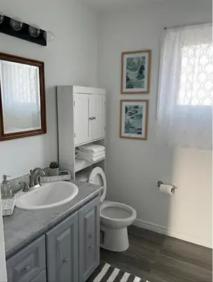 a bathroom with a white sink and a toilet at Family home in Hamilton
