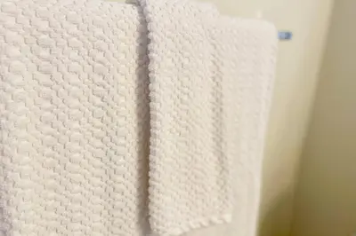 a close up of a white towel hanging on a wall at Top 1% Quiet Private Guestroom 2ppl Old Town NOTL in Niagara on the Lake