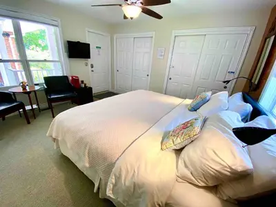 a bedroom with a white bed with a ceiling fan at Top 1% Quiet Private Guestroom 2ppl Old Town NOTL in Niagara on the Lake
