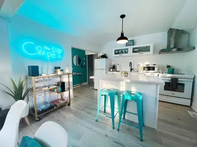 a kitchen with a counter and stools in a room at The Coupe: A Hip Wine Lovers Retreat in NOTL! ✌️ in Niagara on the Lake