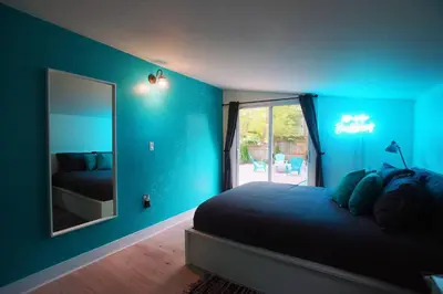 a blue bedroom with a bed and a mirror at The Coupe: A Hip Wine Lovers Retreat in NOTL! ✌️ in Niagara on the Lake