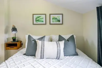 a bedroom with a bed with blue and white pillows at Top 5% Tiny Home by River/Lake in Old Town NOTL in Niagara on the Lake