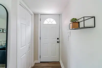 a hallway with a white door and a mirror at Top 5% Tiny Home by River/Lake in Old Town NOTL in Niagara on the Lake