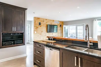 a kitchen with wooden cabinets and a sink at Vineyard 2 Bed Farm Home | Mins to Town & Wineries in Niagara on the Lake
