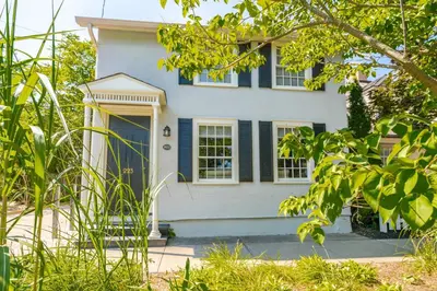 a white house with a blue door and windows at Central Historic Cottage 4ppl in Heart of NOTL in Niagara on the Lake
