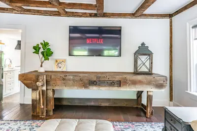 an old wooden desk in a living room with a tv at Central Historic Cottage 4ppl in Heart of NOTL in Niagara on the Lake