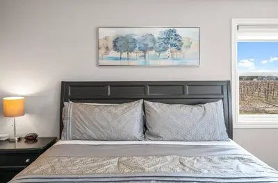 a bedroom with a bed and a picture on the wall at Single Level Vineyard Home | 6 PPL | Pet Friendly in Niagara on the Lake