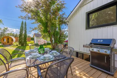 a patio with a table and chairs and a stove at Top 5% Sauna | Bocce Ball | Vineyard Views | NOTL in Niagara on the Lake