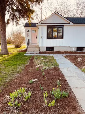 a white house with a walkway in front of a yard at Top 5% Sauna | Bocce Ball | Vineyard Views | NOTL in Niagara on the Lake